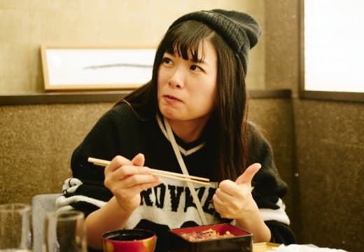 吃烤鳗鱼的妇女